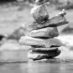 a stack of rocks on a lake in Glacier, national park, Canada